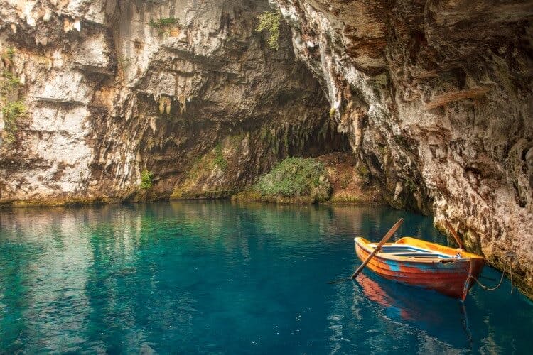 boat floating in water inside cave