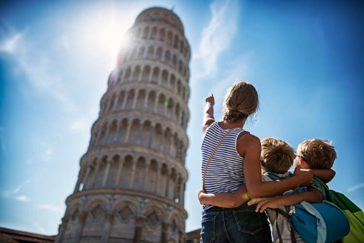 family looking and pointing at leaning tower of pisa