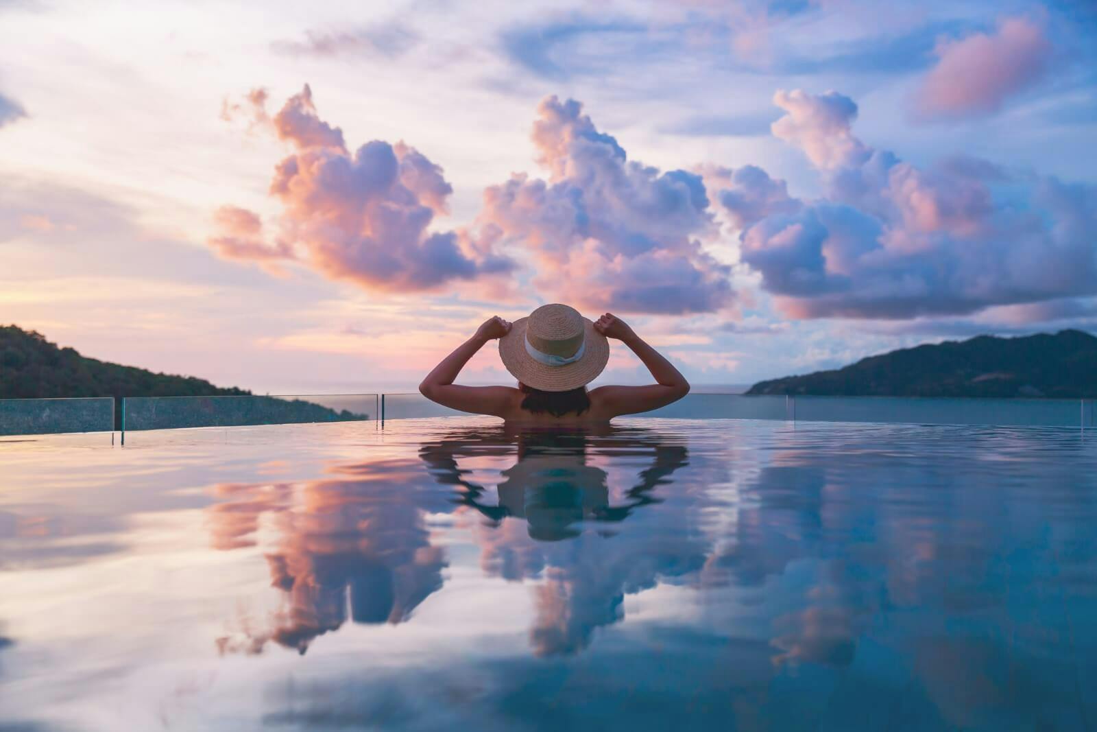 woman in infinity pool at sunset
