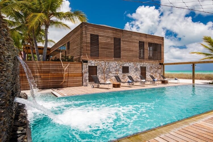 Silver Sands vacation rental - a large wooden building with two stories, sun loungers, and a private pool with a small waterfall