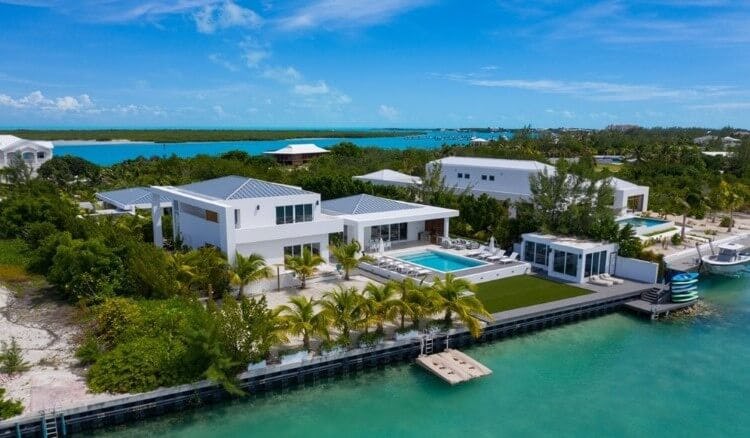 aerial view of white vacation rental next to water