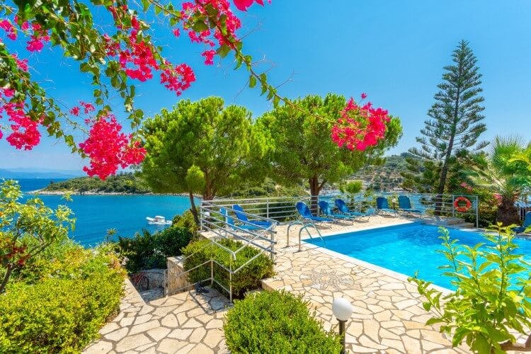 pink flowers, pool in patio with ocean in background