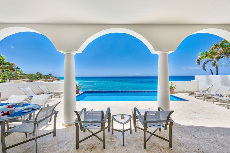 pool overlooking ocean with covered seating