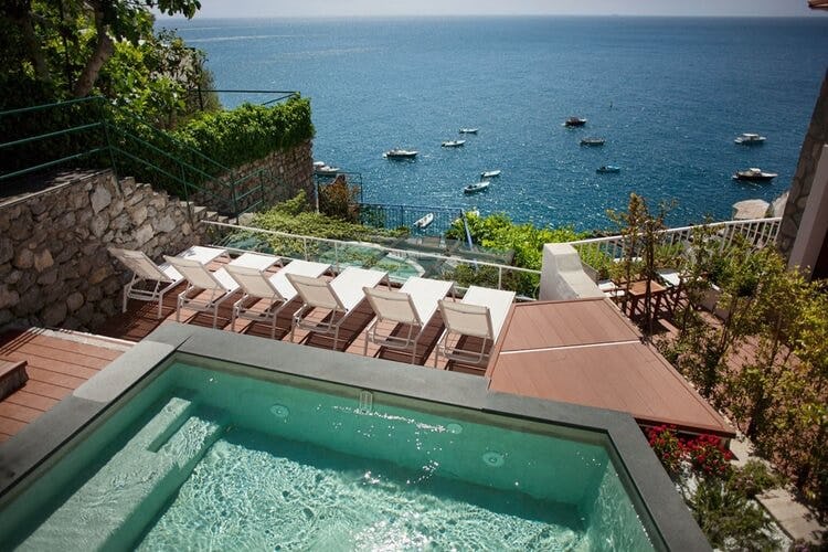 pool with sun loungers overlooking ocean