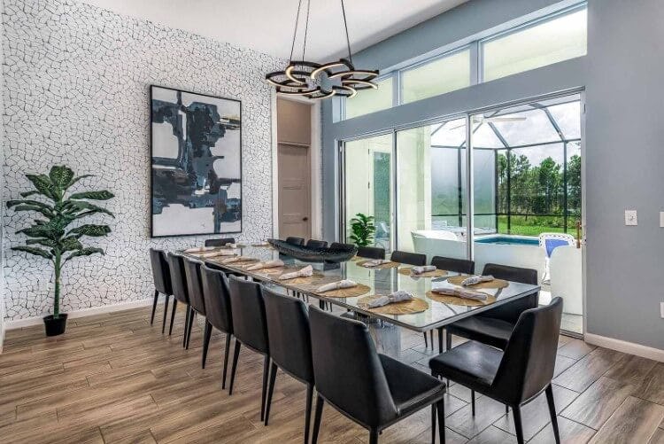 A large dining room at Villatel Village 11 vacation rental with a long glass table and 14 leather chairs