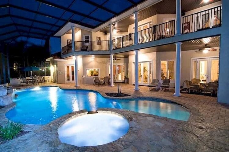 swimming pool and hot tub and white villa at dusk