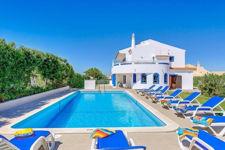 white villa with pool and blue loungers