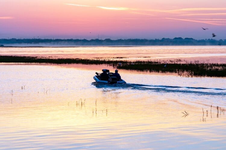 Two men on a boat in Kissimmee at sunrise