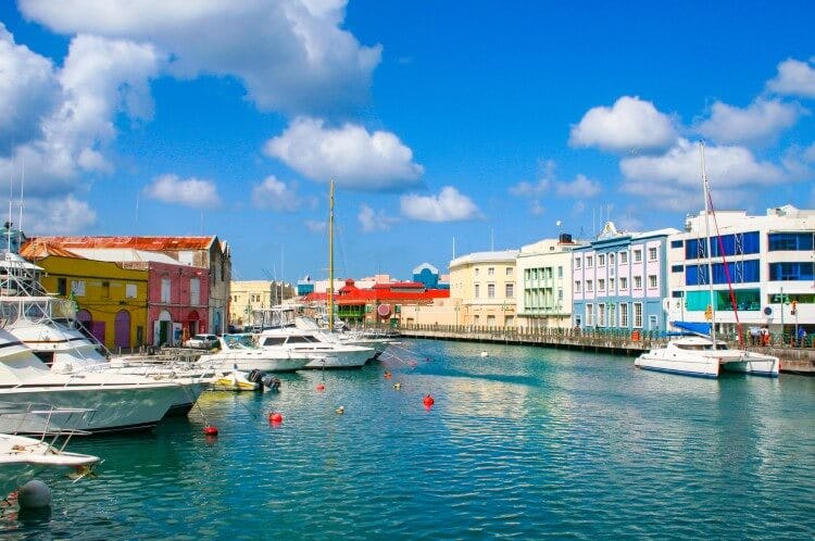 Bridgetown, the capital of Barbados, with colorful buildings lining the waterfront and small fishing boats in the harbor