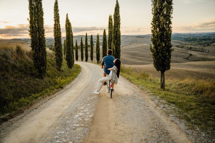 couple riding bike in tuscany