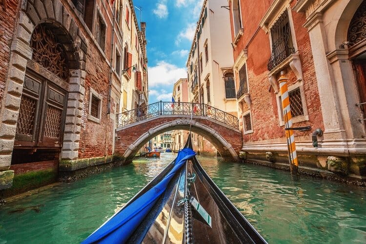 View of a bridge in venice from a gondola on a canal