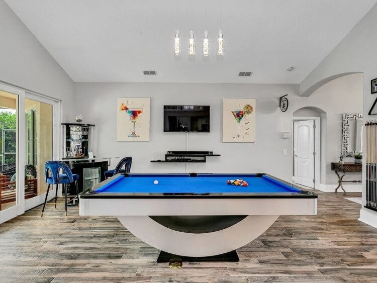 Highlands Reserve 83 vacation rental with games room - a large blue-felted pool table with a modern base in a large room with a television on the wall