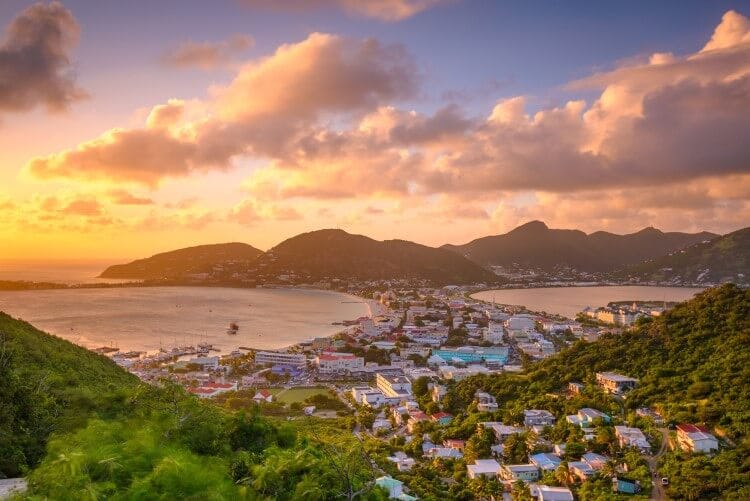 A view of Philipsburg city in Sint Maarten at sunset, with mountains in the backgroup