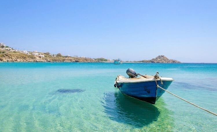 A small fishing boat in clear shallow water at Platis Gialos