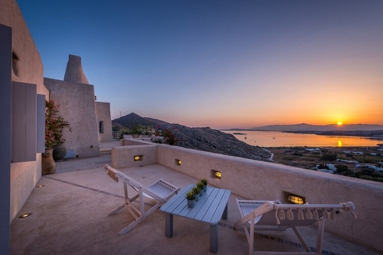 balcony overlooking land and water at sunset
