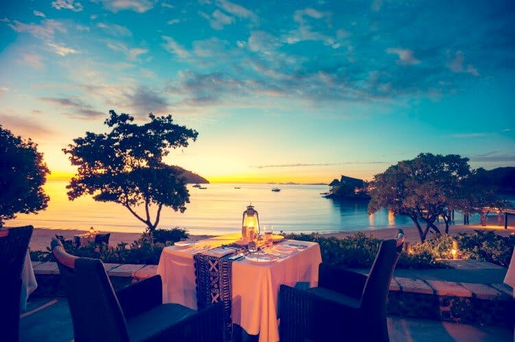 dining table next to sea at sunset