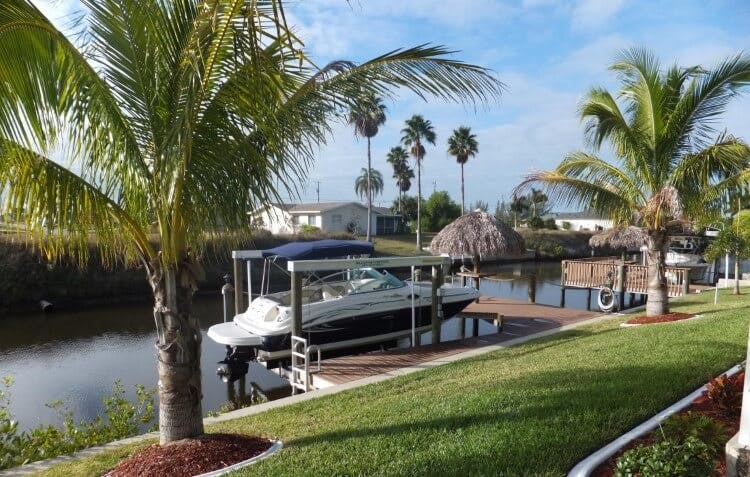 palm tree lined canal with dock and boat