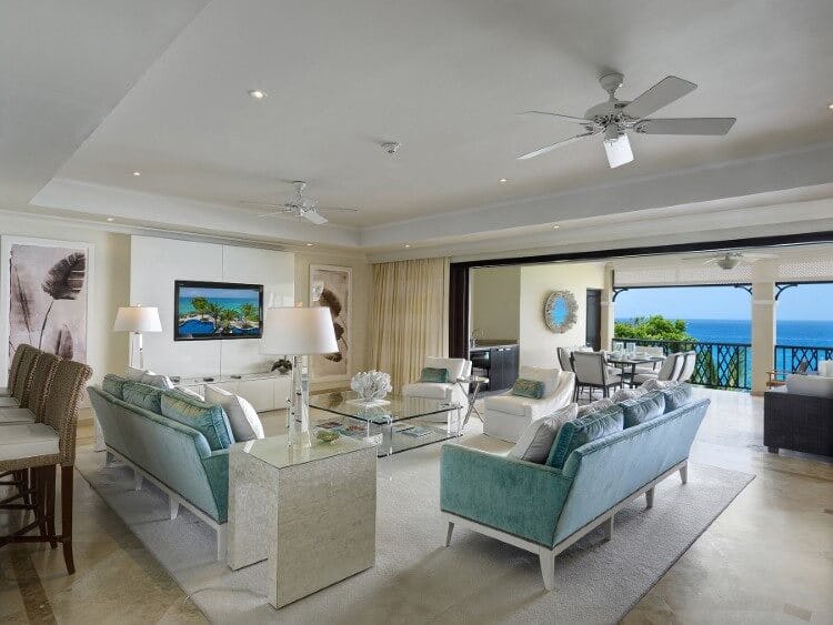 Sandy Cove 302 - image of living room area with couches, lamps, table and view of the Caribbean Sea
