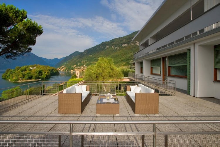 seating area on terrace with lake and mountains in background