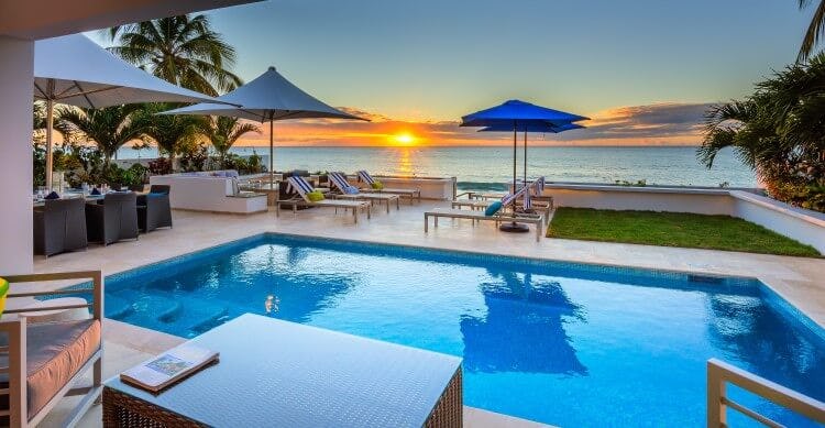 pool and patio overlooking sea at sunset