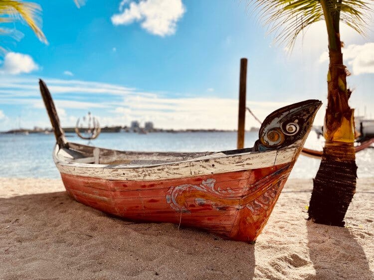 A traditional wooden fishing boat on a white sand beach in Saint Martin