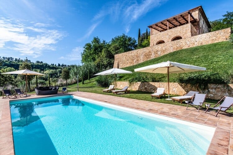 rustic villa on small hill overlooking swimming pool and loungers