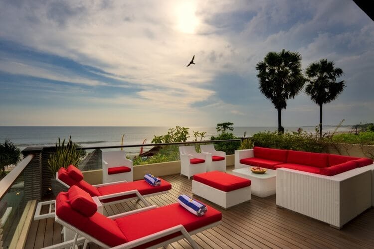 red loungers on balcony with sea in background