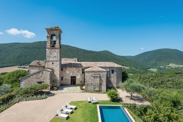 rustic villa with tower with hills in background