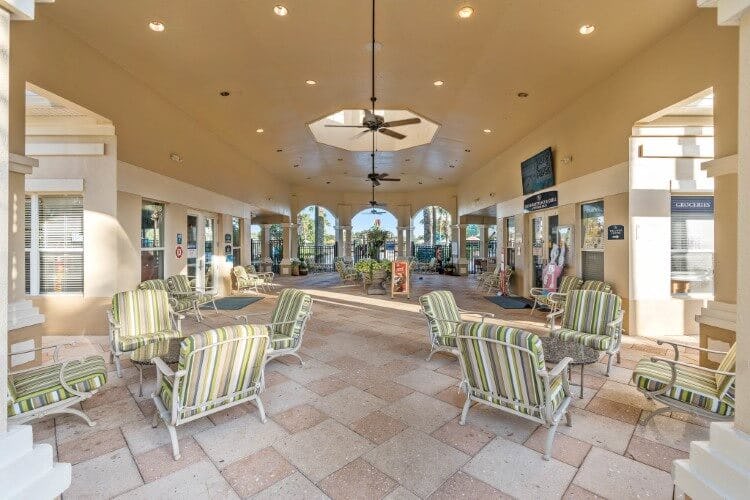 Windsor Hills Resort clubhouse, showing cushioned chairs around small circular tables on a tiled floor, with arched windows and doorways and a high ceiling with fans