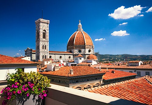 The red dome of the Florence cathedral and tower as seen from a nearby rooftop