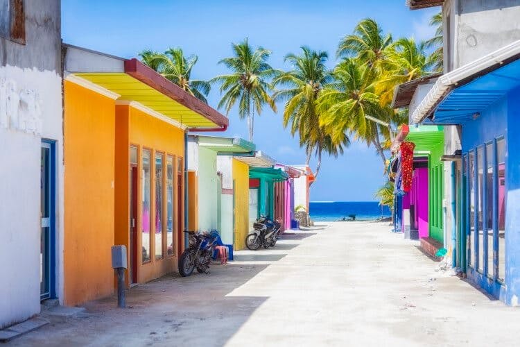 colorful row of houses with ocean at the end