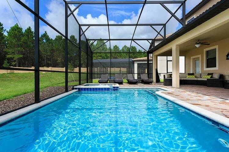 covered pool with greenery and trees beyond glass