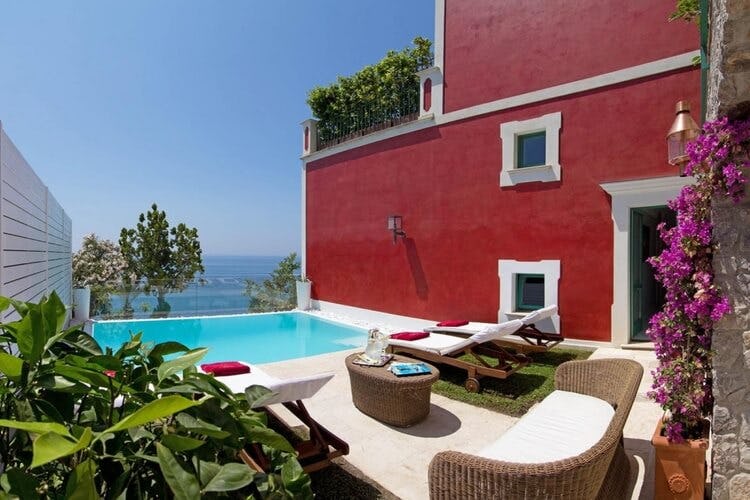 red villa with pool overlooking ocean