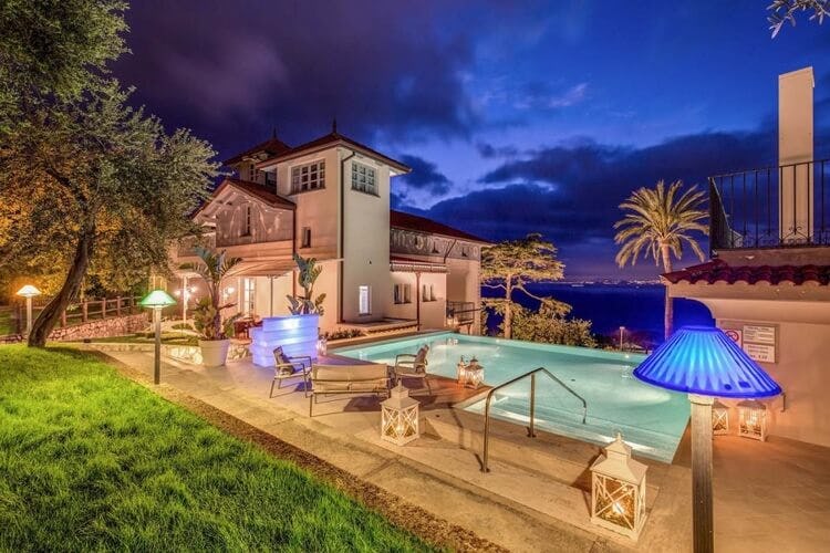lit up villa and pool at dusk