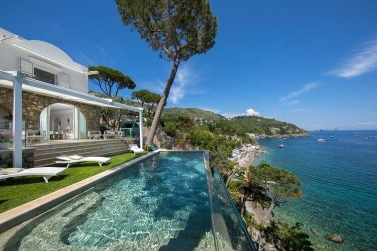 white villa with swimming pool overlooking ocean