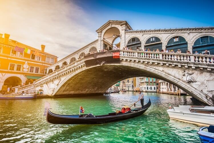 gondola underneath a bridge in venice
