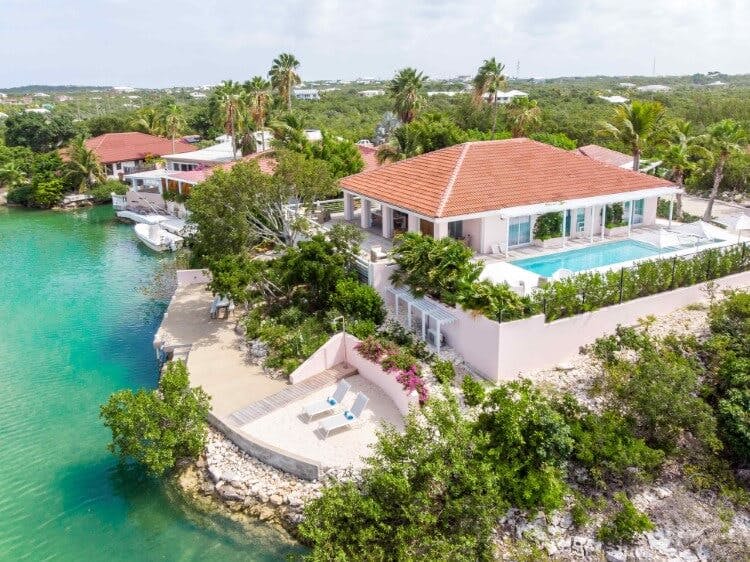 aerial view of water side villa with pool and loungers