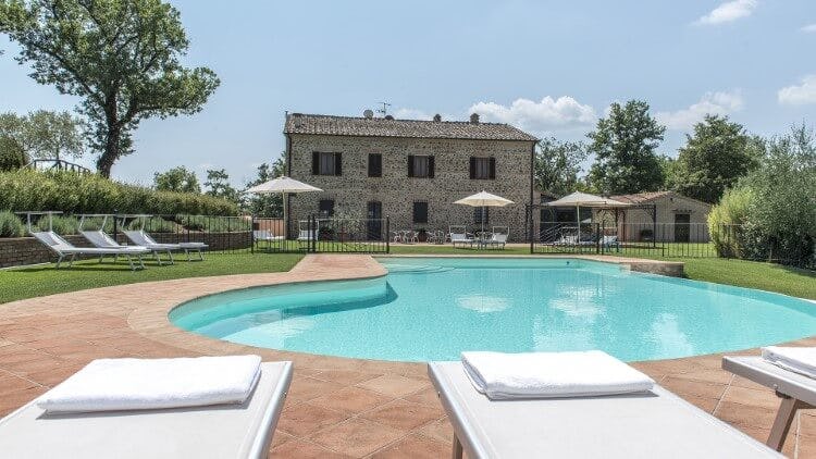stone villa with oblong pool and loungers
