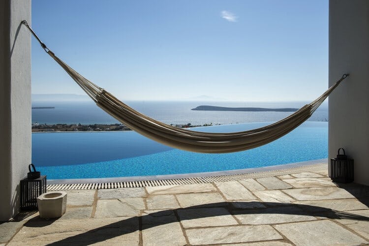 hammock on patio with pool and sea beyond