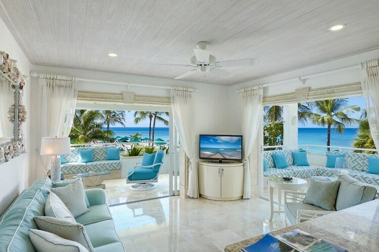 living room with open doors looking out onto ocean