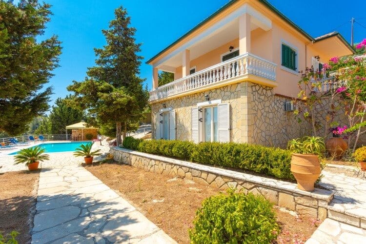 stone and yellow villa with path leading to pool