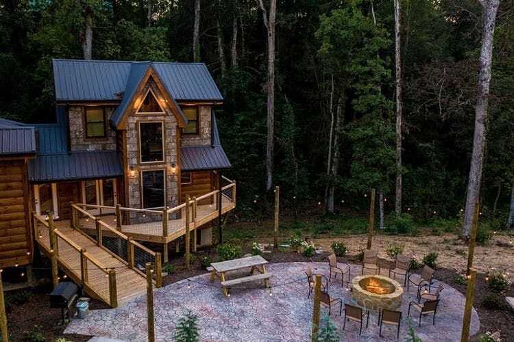 large cabin in woods with fire pit