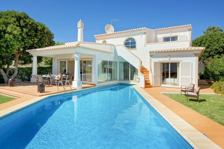 white villa with covered patio area and pool
