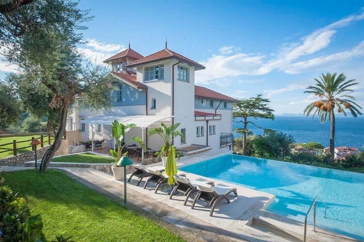 white villa with pool overlooking ocean