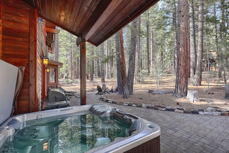 cabin with a hot tub in the woods