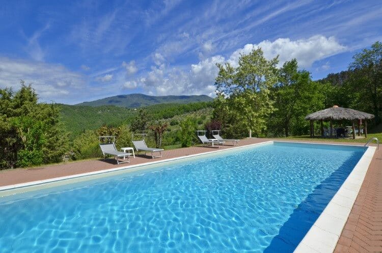 long swimming pool with tuscan countryside in background