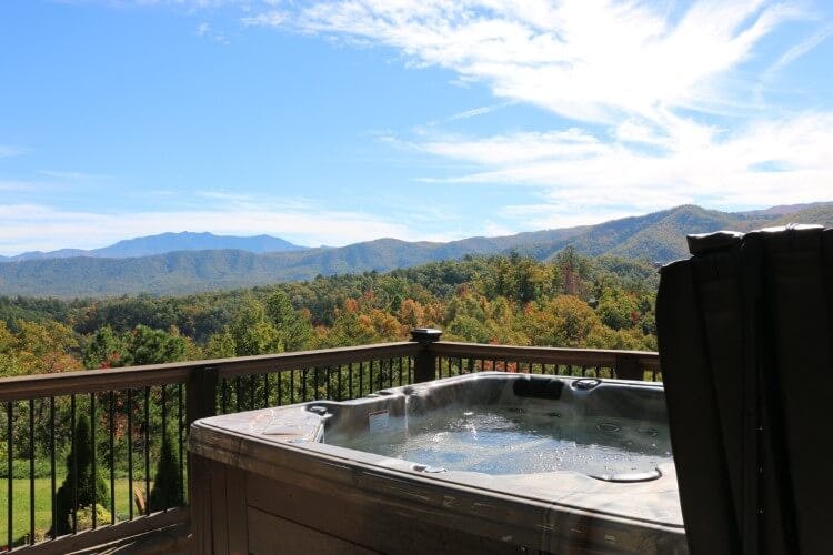hot tub on balcony overlooking trees and mountain