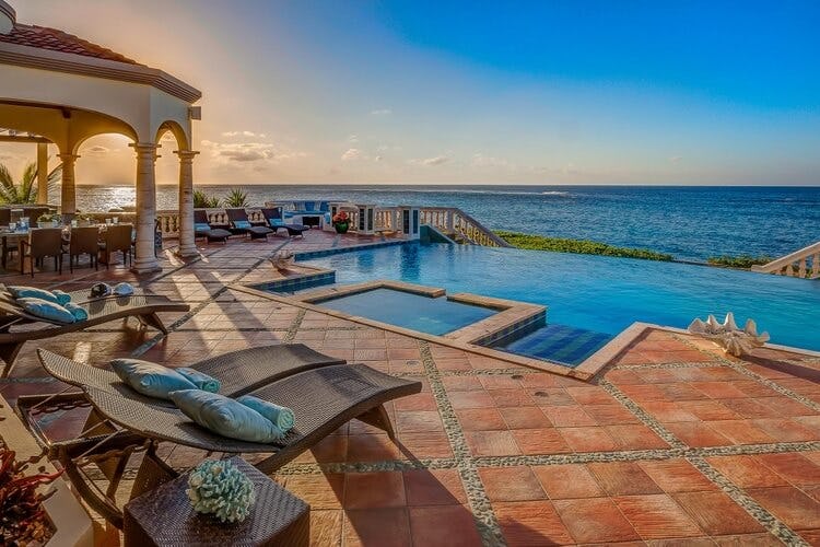 pool, jacuzzi and sun loungers overlooking ocean