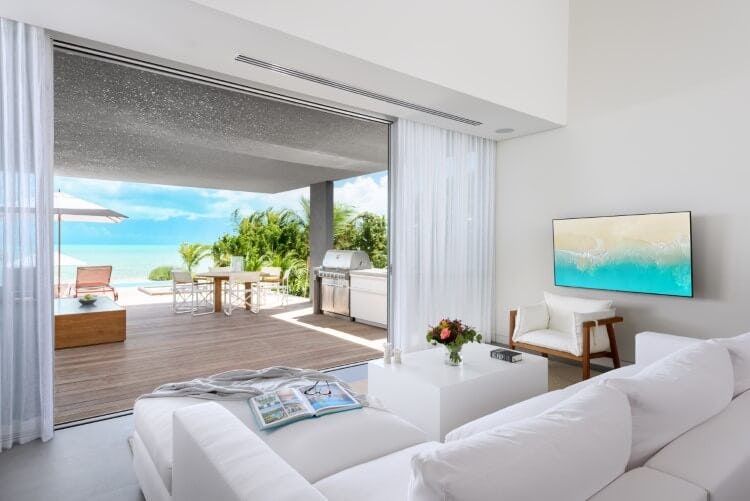 living room with open doors leading to balcony overlooking ocean
