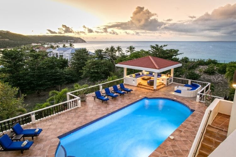 patio pool and seating area overlooking ocean at sunset